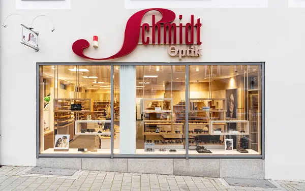 Schaufenster eines modernen Optikgeschäfts mit Brillen und stilvoller Ladeneinrichtung.